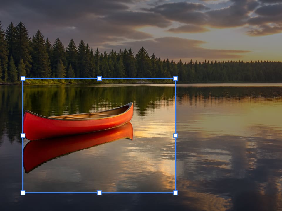 A red canoe on a pine lake with a blue crop box around the boat; the dim water around it is the part this crop throws away.